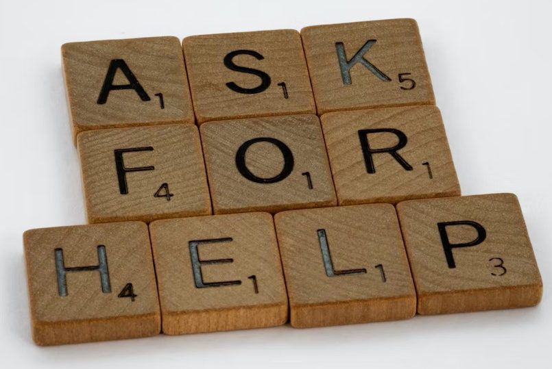 Scrabble pieces forming the phrase 'ask for help'