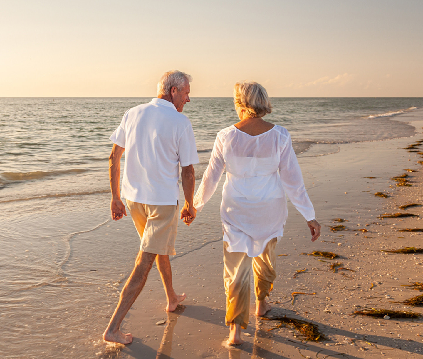 Elderly couple walking down a beach